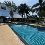 a pool with palm trees and buildings